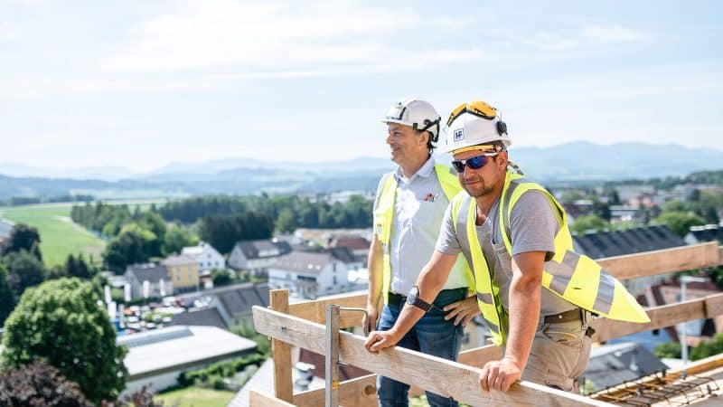 Arbeiter von Held & Francke schauen vom Dach aus in die Ferne